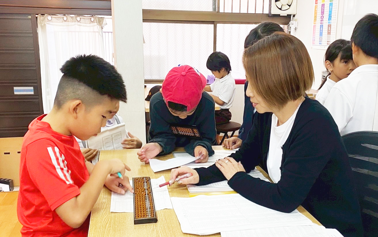そろばんの指導を受ける子供たち