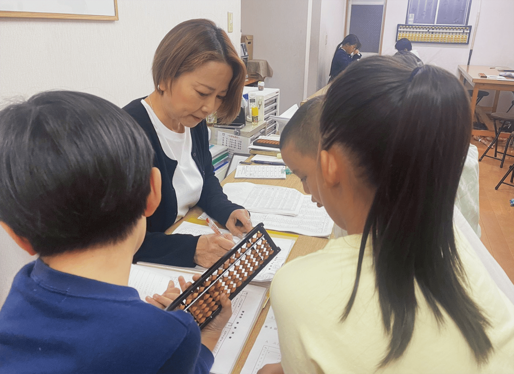 そろばんの指導を受ける子供たち